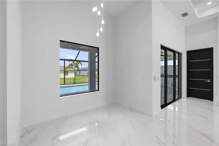 Unfurnished room featuring a high ceiling and marble tiled flooring