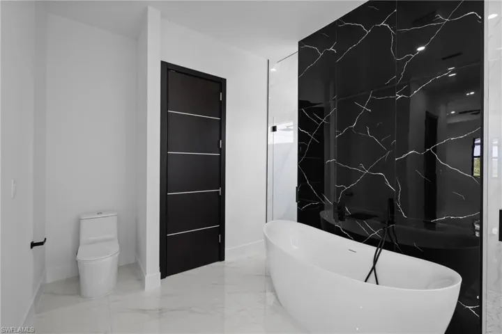 Bathroom with a freestanding tub and marble tiled floors