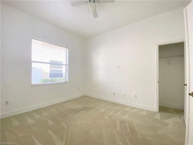 Second bedroom with ceiling fan and light colored carpet