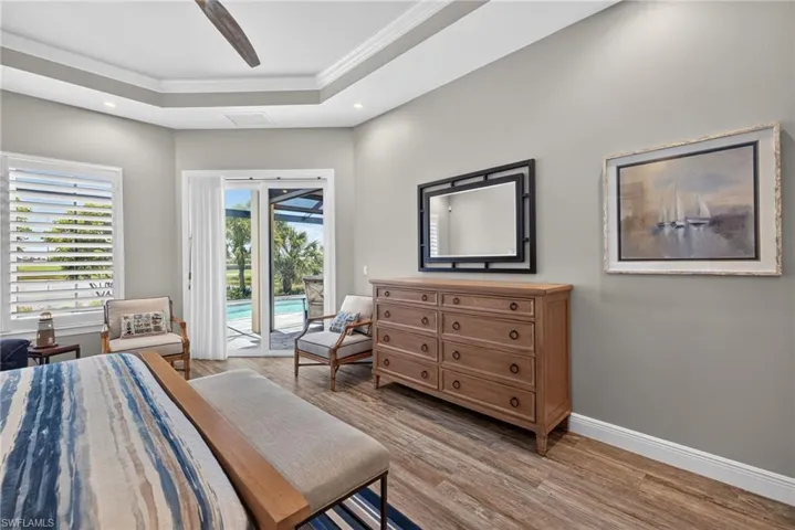 Primary Bedroom recessed lighting illuminates a tray ceiling with crown molding