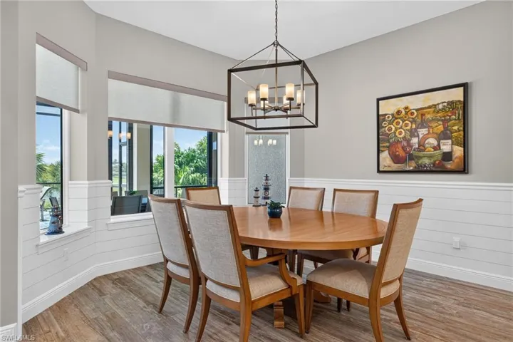 Dining area featuring wood-finish flooring and white shiplap wainscoting