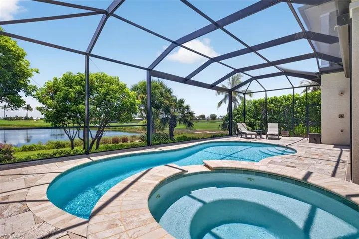 Screened lanai featuring a freeform pool and integrated spa