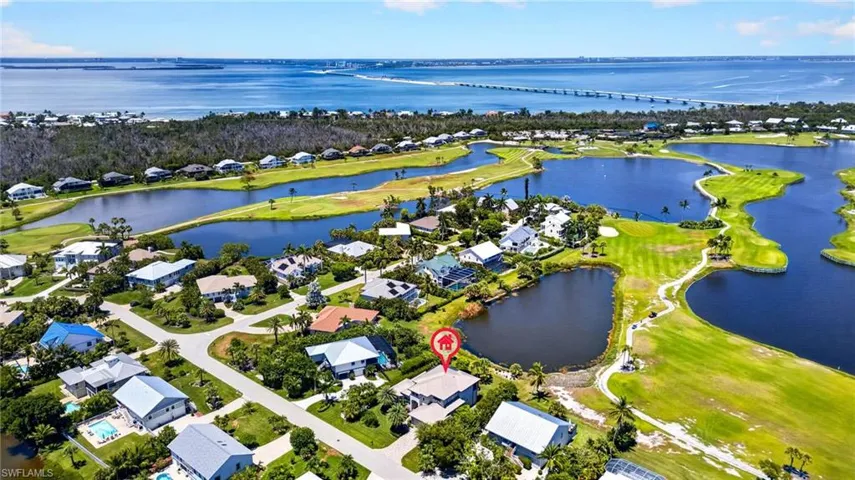 Aerial perspective showcasing a residential community with abundant green spaces and water features