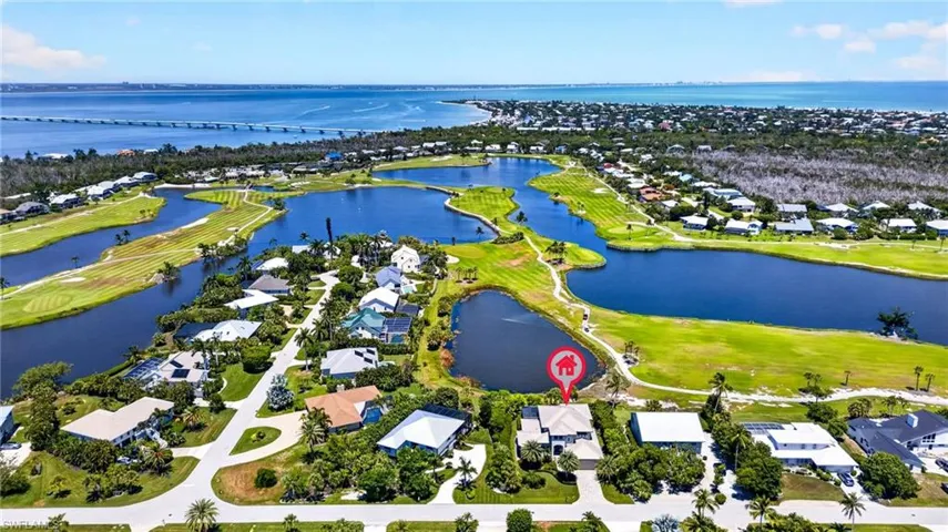 Aerial perspective showcasing a residential property with a direct view of a water feature and golf course