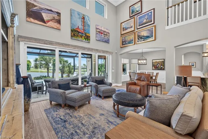 Two-story living area with high ceilings, wood-finish flooring, and ample natural light