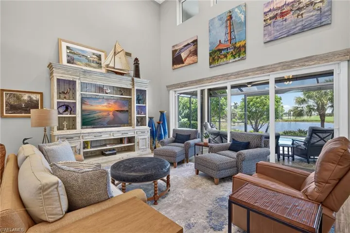 Living area featuring a floor-to-ceiling entertainment center, vaulted ceilings, and large sliding glass doors