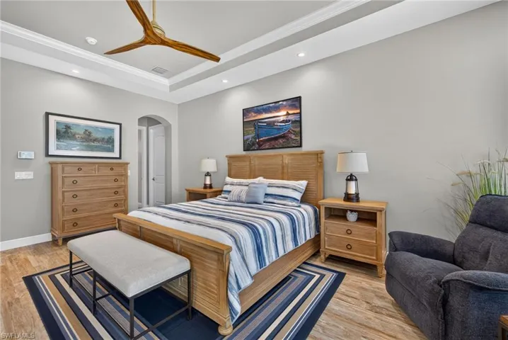 Primary Bedroom recessed lighting illuminates a tray ceiling with crown molding