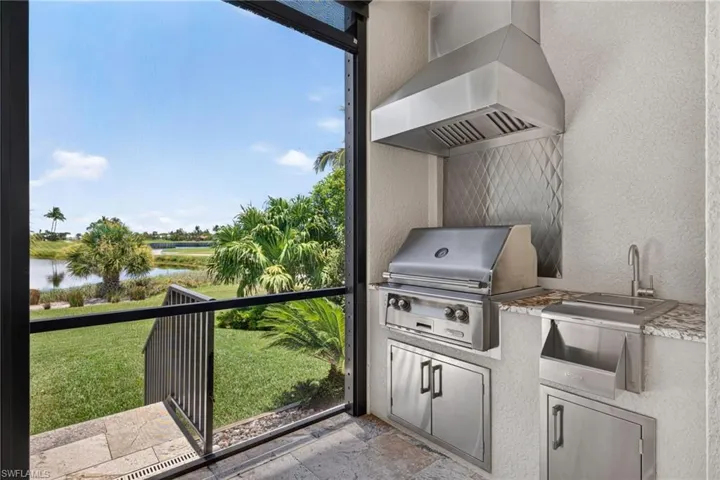Outdoo Kitchen featuring an outdoor kitchen with stainless steel appliances, a range hood, and a built-in sink
