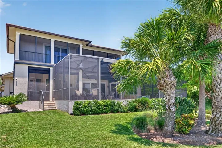 Two-story stucco exterior featuring multiple screened enclosures, a ground-level covered patio, and a second-story balcony