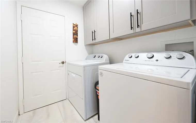Washroom with cabinet space and washing machine and dryer