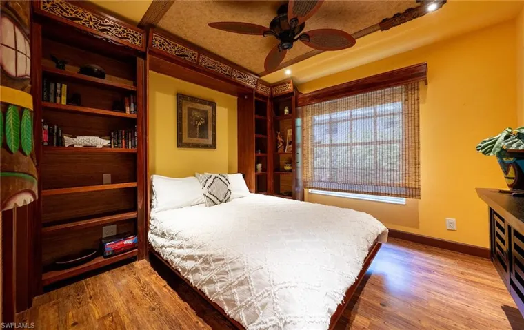 Bedroom featuring baseboards, wood finished floors, and a ceiling fan