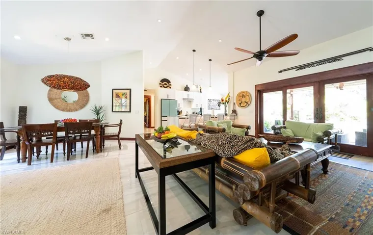 Living room featuring ceiling fan, high vaulted ceiling, french doors, and light tile patterned floors