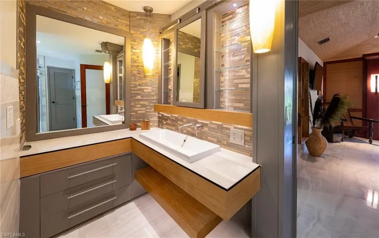 Bathroom with decorative backsplash, vanity, lofted ceiling, and a textured ceiling