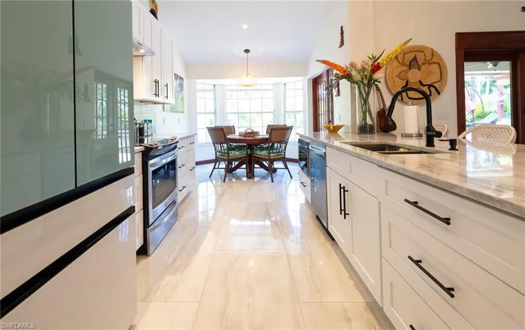 Kitchen with appliances with stainless steel finishes, plenty of natural light, and white cabinetry