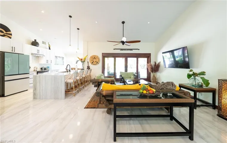 Living room with ceiling fan and high vaulted ceiling