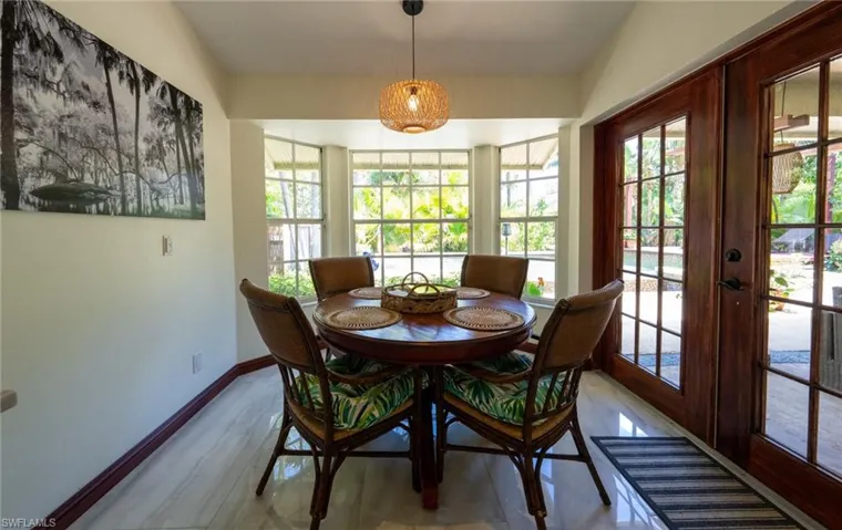Dining area with light wood-style flooring, baseboards, and french doors
