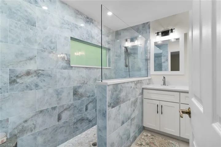 Full bathroom featuring a walk in shower, vanity, and recessed lighting