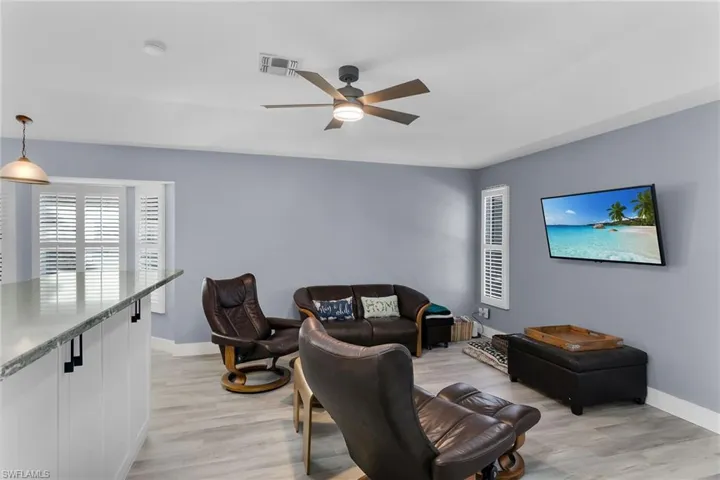 Living room with light wood-type flooring and ceiling fan