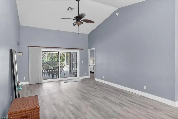 Unfurnished living room featuring high vaulted ceiling, a ceiling fan, and light wood finished floors
