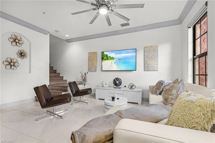 Living room featuring ornamental molding, a ceiling fan, marble finish floors, recessed lighting, and stairs
