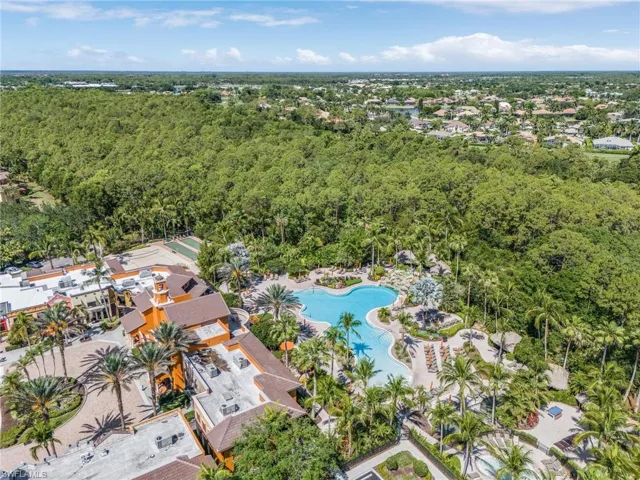 Aerial view of property's location featuring a heavily wooded area and a pool area