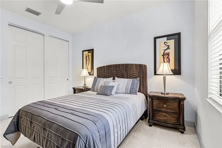 Bedroom with a ceiling fan, a closet, and light marble finish flooring