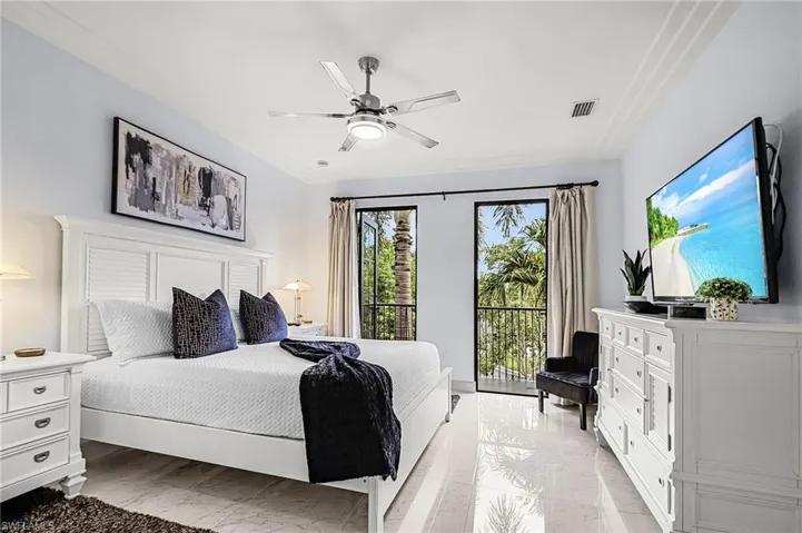 Bedroom with ceiling fan, light marble finish flooring, ornamental molding, and access to outside