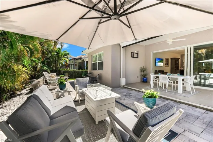 Lanai with an outdoor living space a fire pit, ceiling fan, and outdoor dining space.