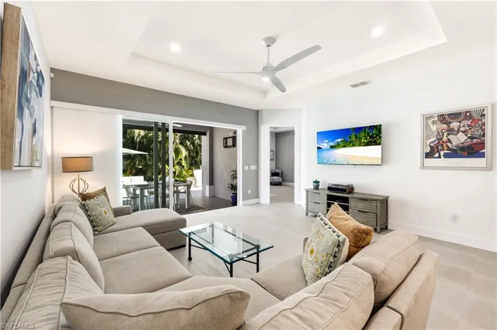 Living area with view of lanai and motorized vertical shades.