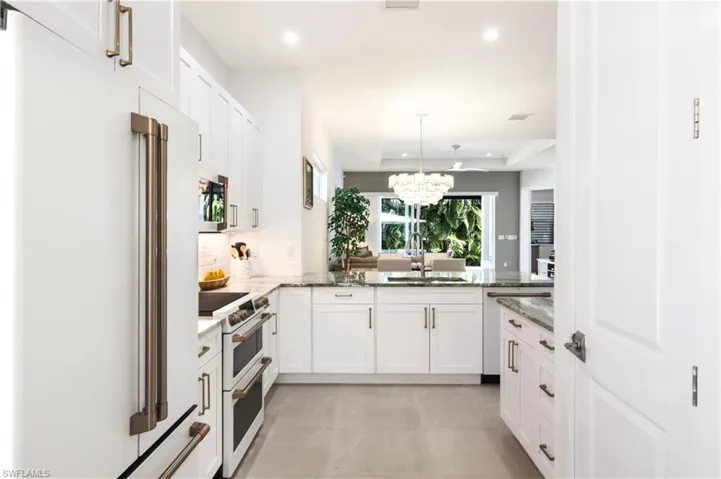 Kitchen featuring white Shaker style 42"cabinets white GE Cafe appliances.