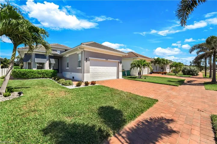View of front façade featuring decorative paver driveway, an attached 2 car garage.