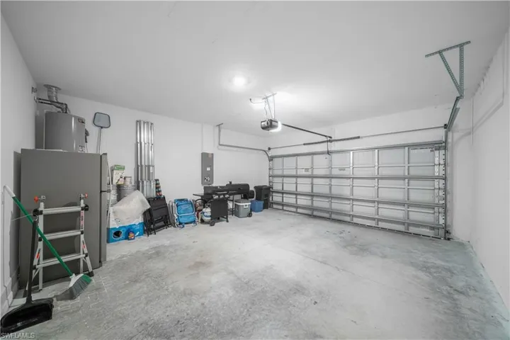 Spacious garage with a sectional garage door, concrete flooring, and overhead lighting