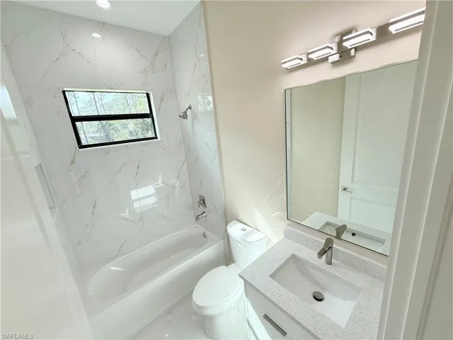 Bathroom featuring vanity,  shower combination, and marble finish floors