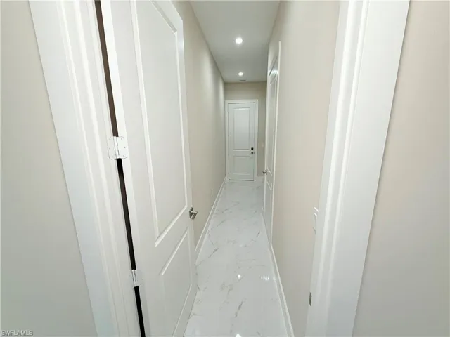 Corridor with light marble finish flooring and recessed lighting