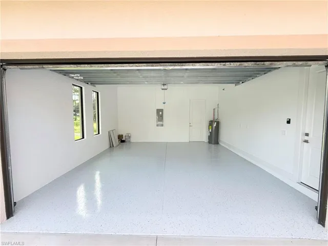 Garage featuring electric water heater and electric panel