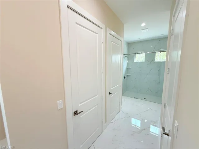 Corridor with light marble finish flooring and recessed lighting