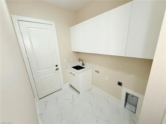 Laundry room featuring light marble finish floors, washer hookup, cabinet space, and hookup for an electric dryer