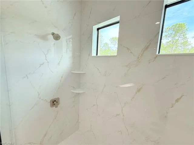 Full bathroom with a marble finish shower