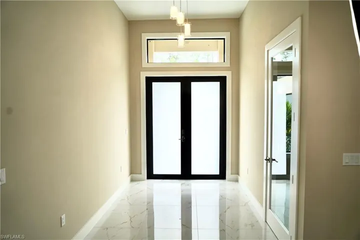 Entryway featuring french doors and marble finish floors