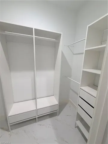 Walk in closet with marble look tile flooring