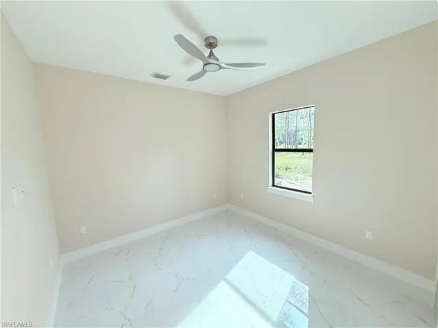 Empty room featuring marble finish flooring and ceiling fan
