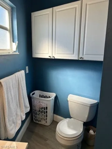 Bathroom with toilet and grey  wood finished floors