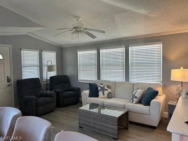 Living area featuring crown molding, ceiling fan, and wood finished floors