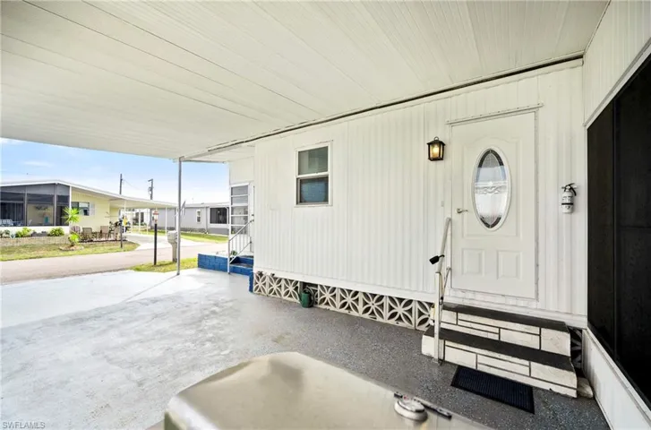 Entrance to property with a porch and an attached carport