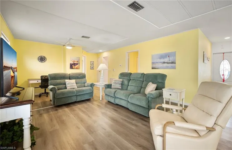 Living room with light wood-style floors, recessed lighting, and a ceiling fan