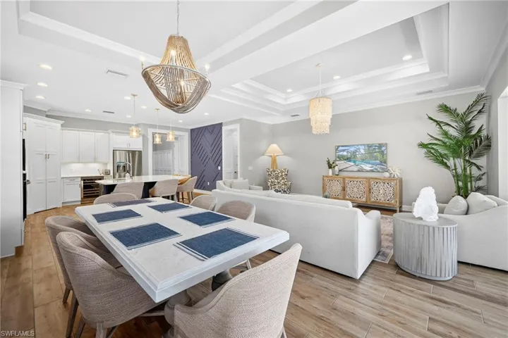 Open-concept living space featuring wood-finish flooring and tray ceilings