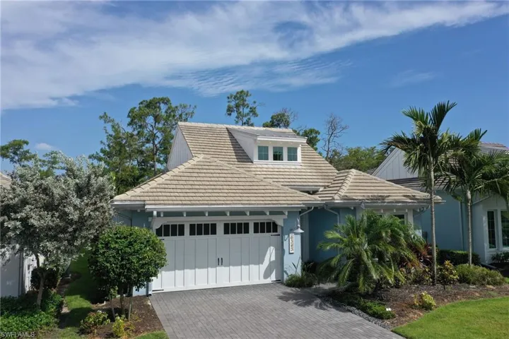 Coastal-inspired exterior featuring a light blue facade and a multi-gabled tile roof