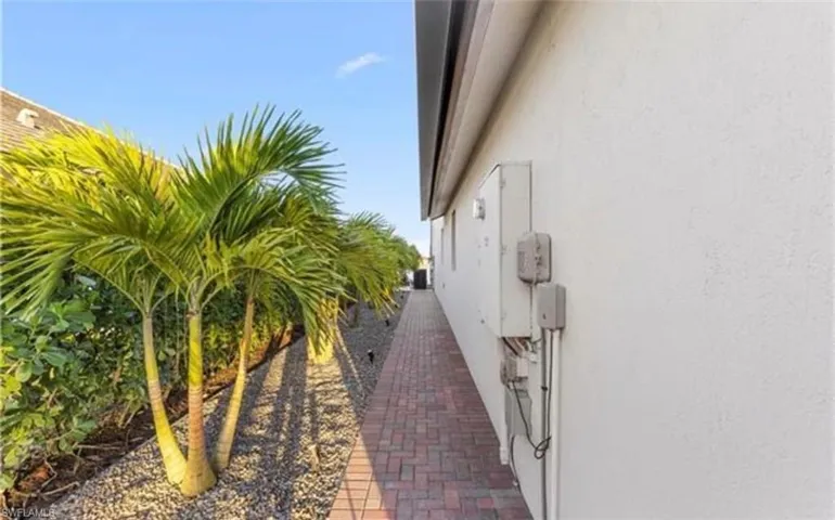 Brick paver pathway alongside a stucco exterior