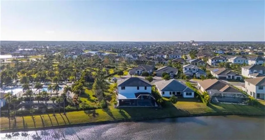 Expansive residential community featuring numerous single-family homes, mature landscaping, and a central aquatic amenity