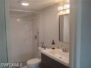 Full bath with vanity and a marble finish shower